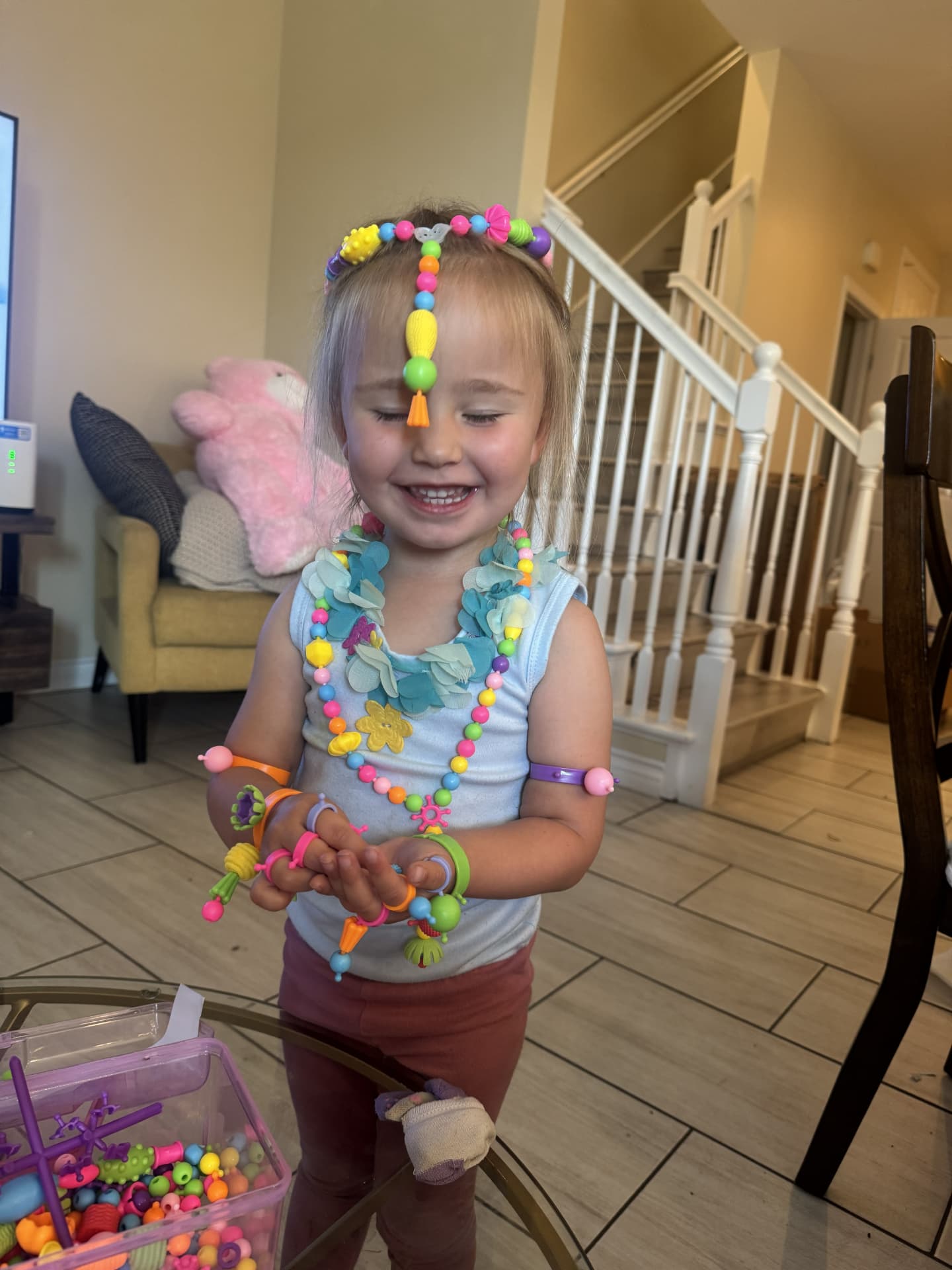 A smiling child wearing colorful bead necklaces and bracelets